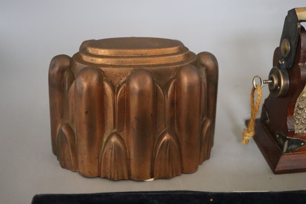 A miniature two bottle tantalus, height 17cm, a brass jelly mould and a cased multiplier